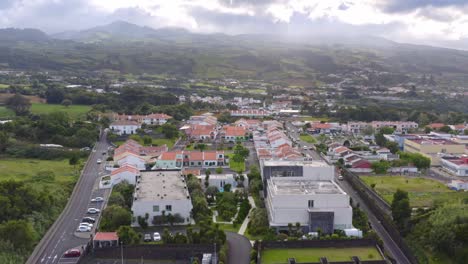 Residential-block-with-houses-and-parking-lots-below-cloudy-mountains