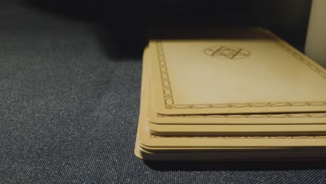 close up shot of person giving tarot card reading laying down the wheel of fortune card on table