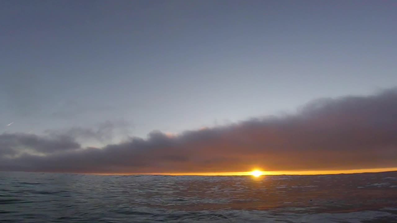surfista mostrando una increíble puesta de sol con go pro