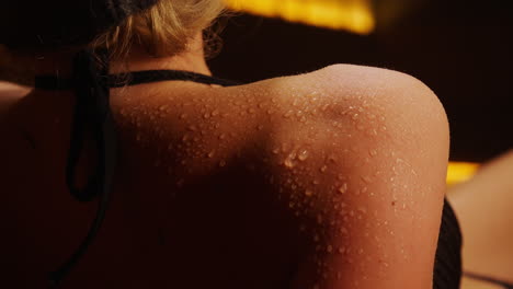 woman's wet shoulder in a sauna