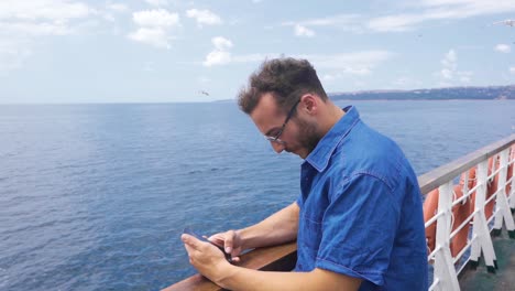 man looking at phone on sea voyage in slow motion.