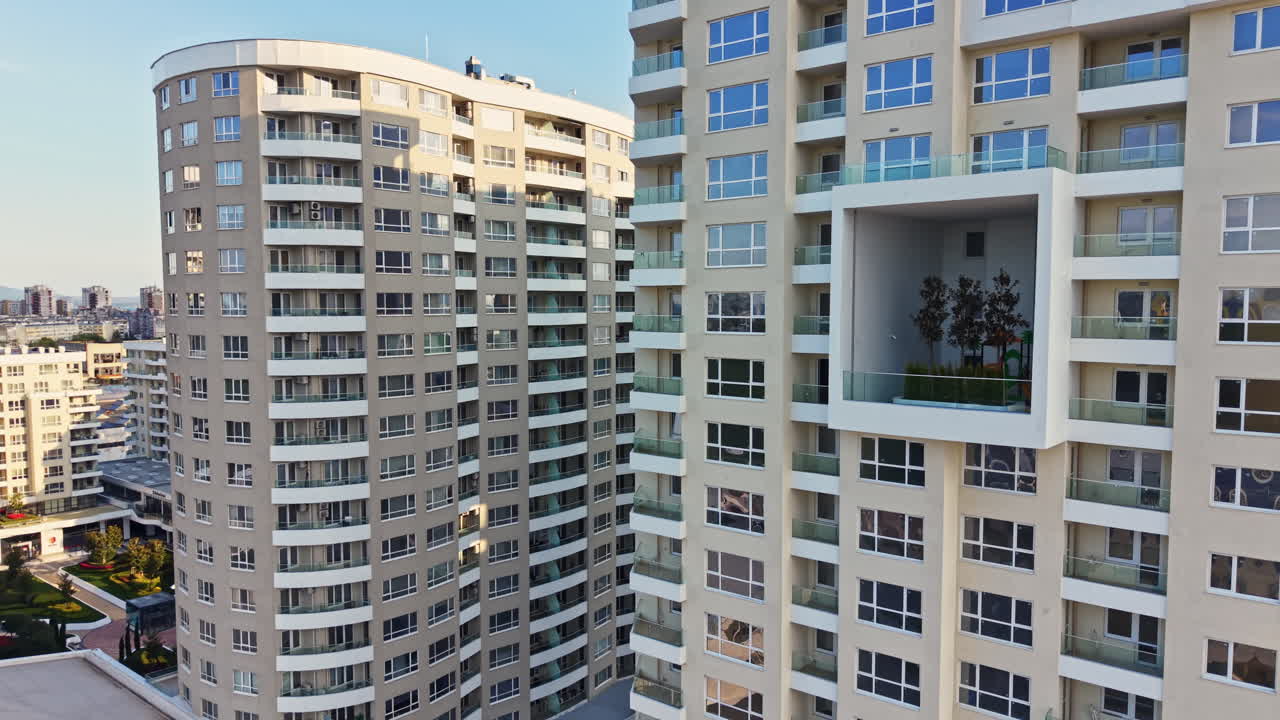 Novos edifícios de apartamentos se erguem em uma área urbana moderna com vista para o horizonte da cidade durante o dia.