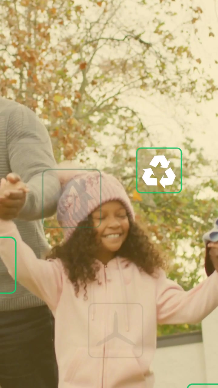 Vertical video: Cam panning, pa holding girl's hand walking, green icons over family showing energy