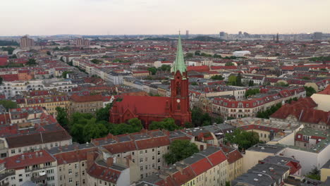 Panoramic-curve-footage-of-buildings-in-urban-neighbourhood-in-city.-Old-brick-sacral-building-of-Gethsemane-Church-in-middle.-Berlin,-Germany