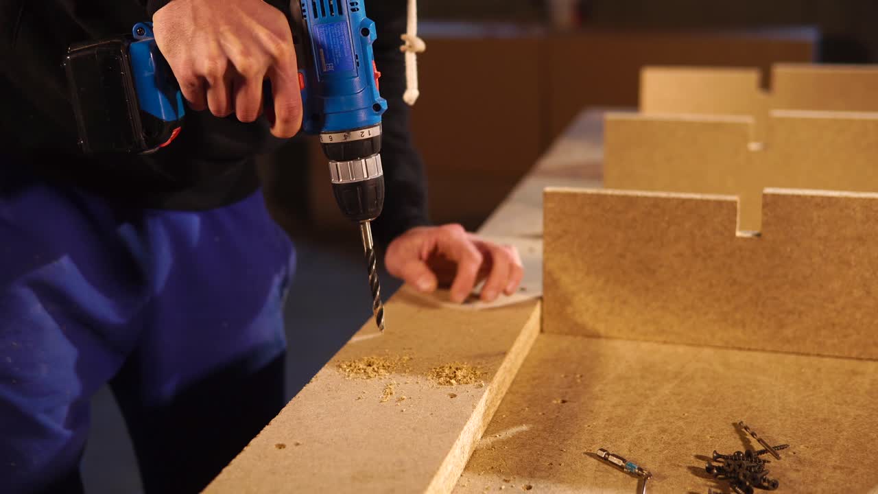 나무 부품 을 조립 하기 위해 드릴 을 사용하는 사람