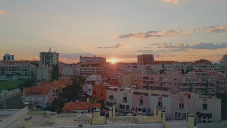 calm urban sunset drone view over cozy residential buildings. golden sun setting