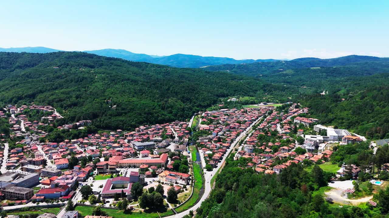 Dronen svæver over Tryavnas bybillede og viser terrakottatage, parker, floden og de omkringliggende grønne bakker, der former landsbyens dal.