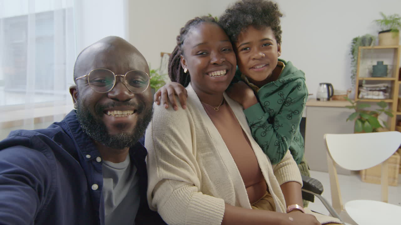 Happy Woman in Wheelchair and Family Talking on Web Call