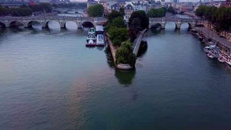 flying over seine river towards ile de la cite, notre dame cathedral and pont neuf bridge in paris, france