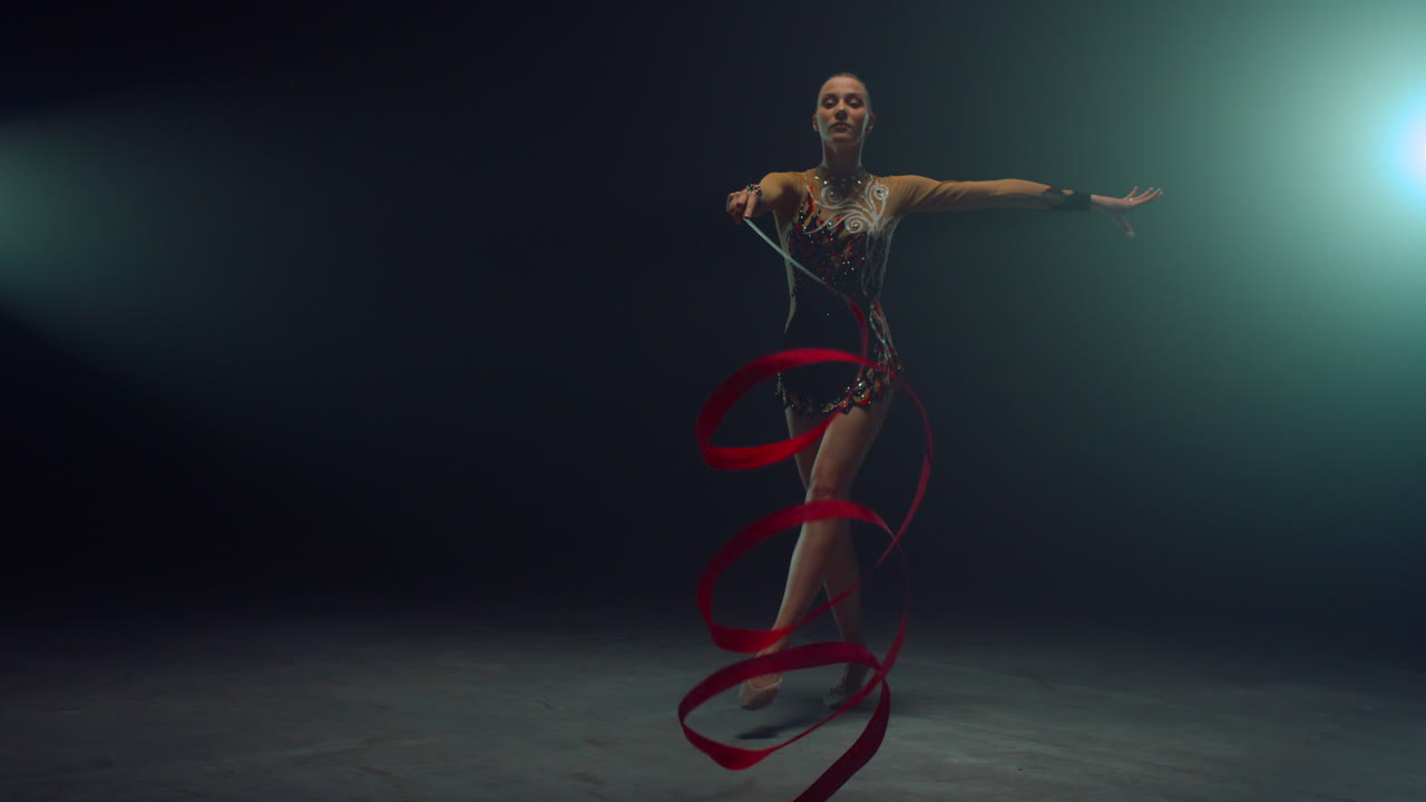 una ragazza flessibile che mostra elementi di ginnastica con un nastro. una ginnasta che balla con un nastro.