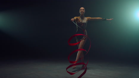 chica flexible mostrando elementos de gimnasia con cinta. gimnasta bailando con cinta.