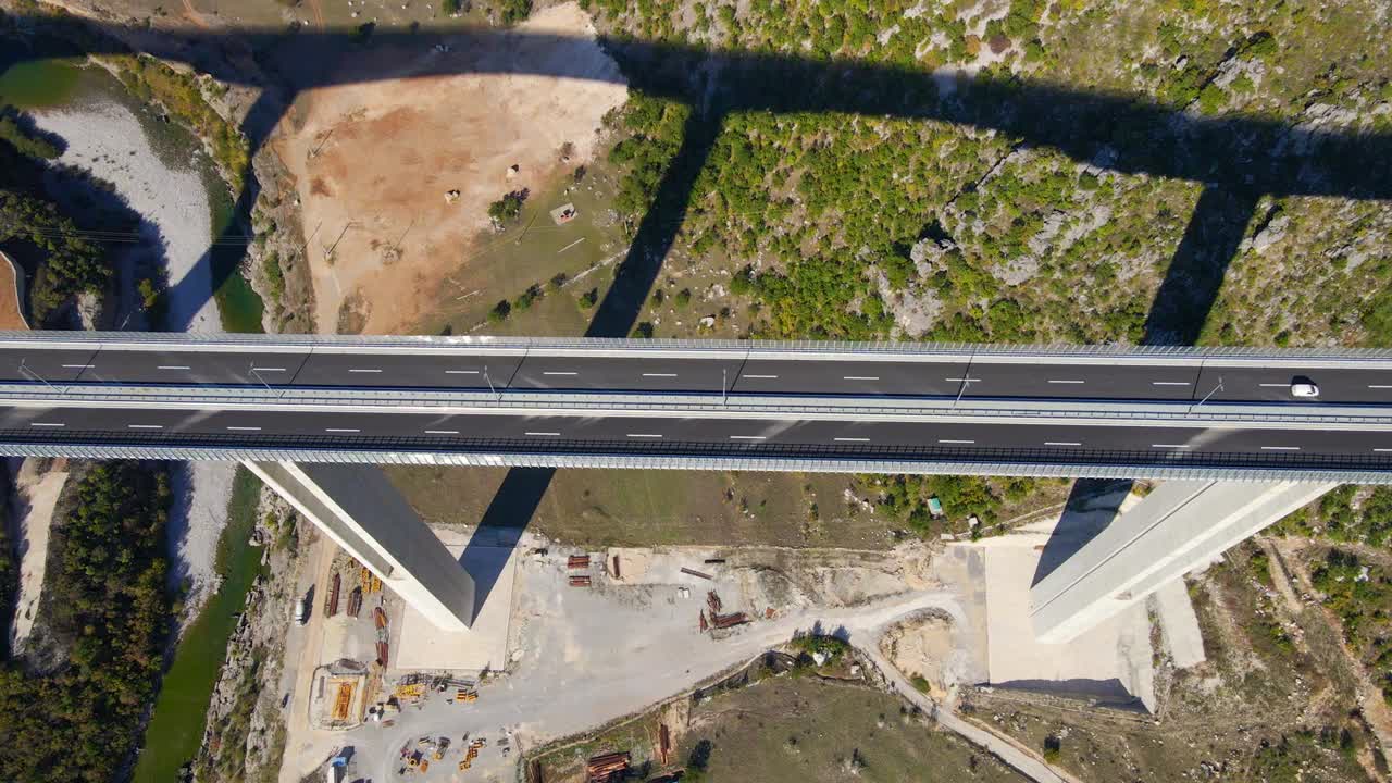 fotografía aérea del puente moracica completamente terminado en montenegro. el gran escudo de armas rojo de montenegro se ve en uno de los pilares del puente