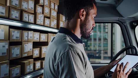delivery driver using tablet in delivery van
