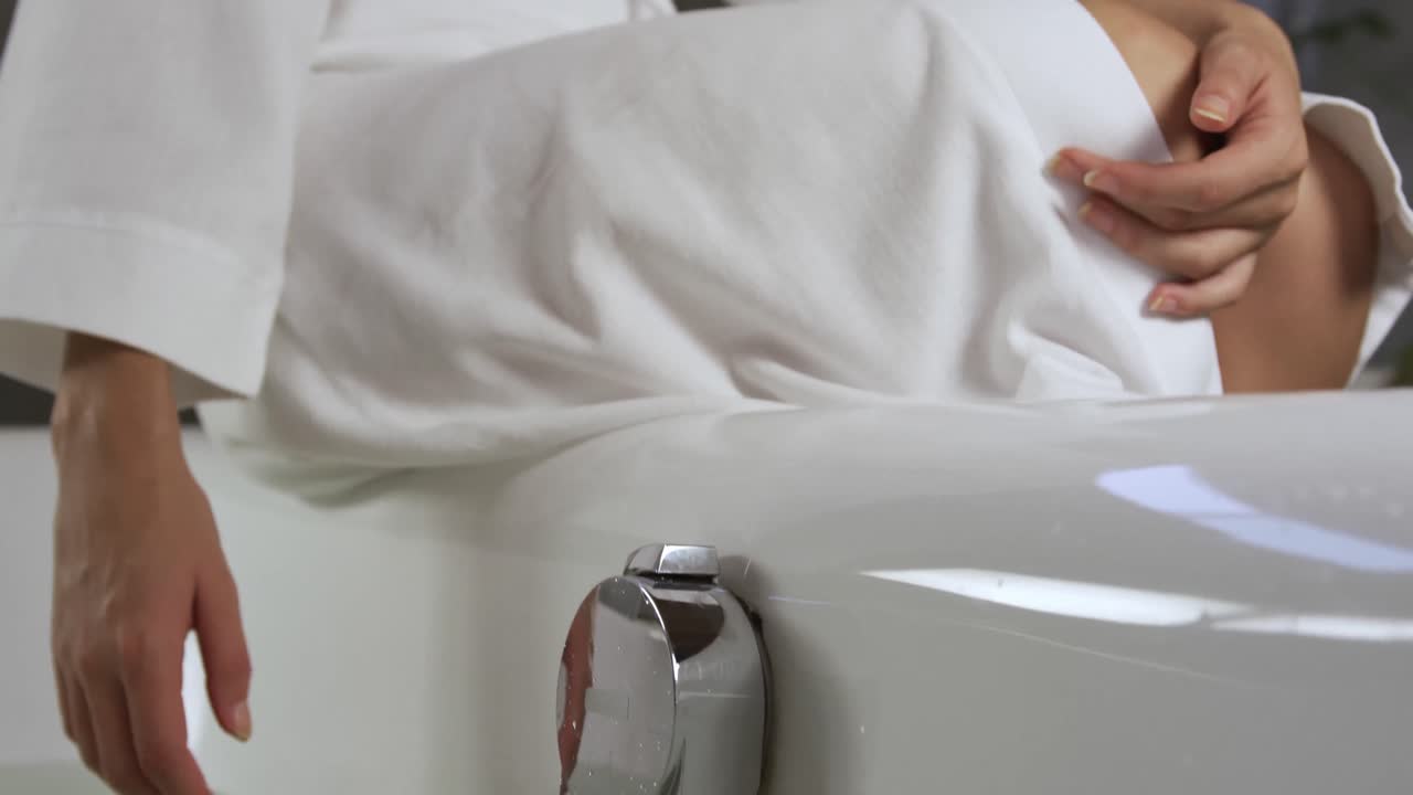 mujer caucásica probando la temperatura del baño en el hotel