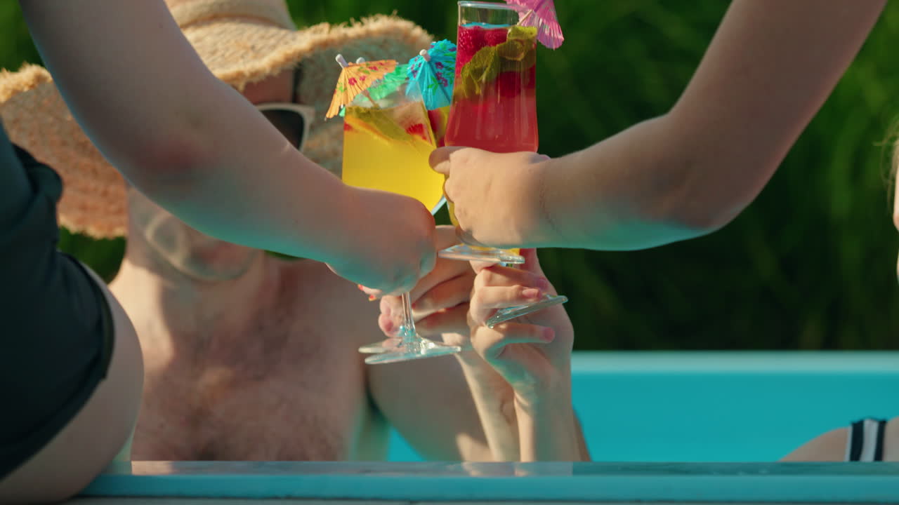 Amici che brindano con cocktail a bordo piscina