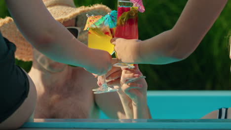 amigos brindando cócteles junto a la piscina