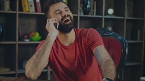 Happy-man-talking-mobile-phone-at-home-workplace.-Smiling-business-man