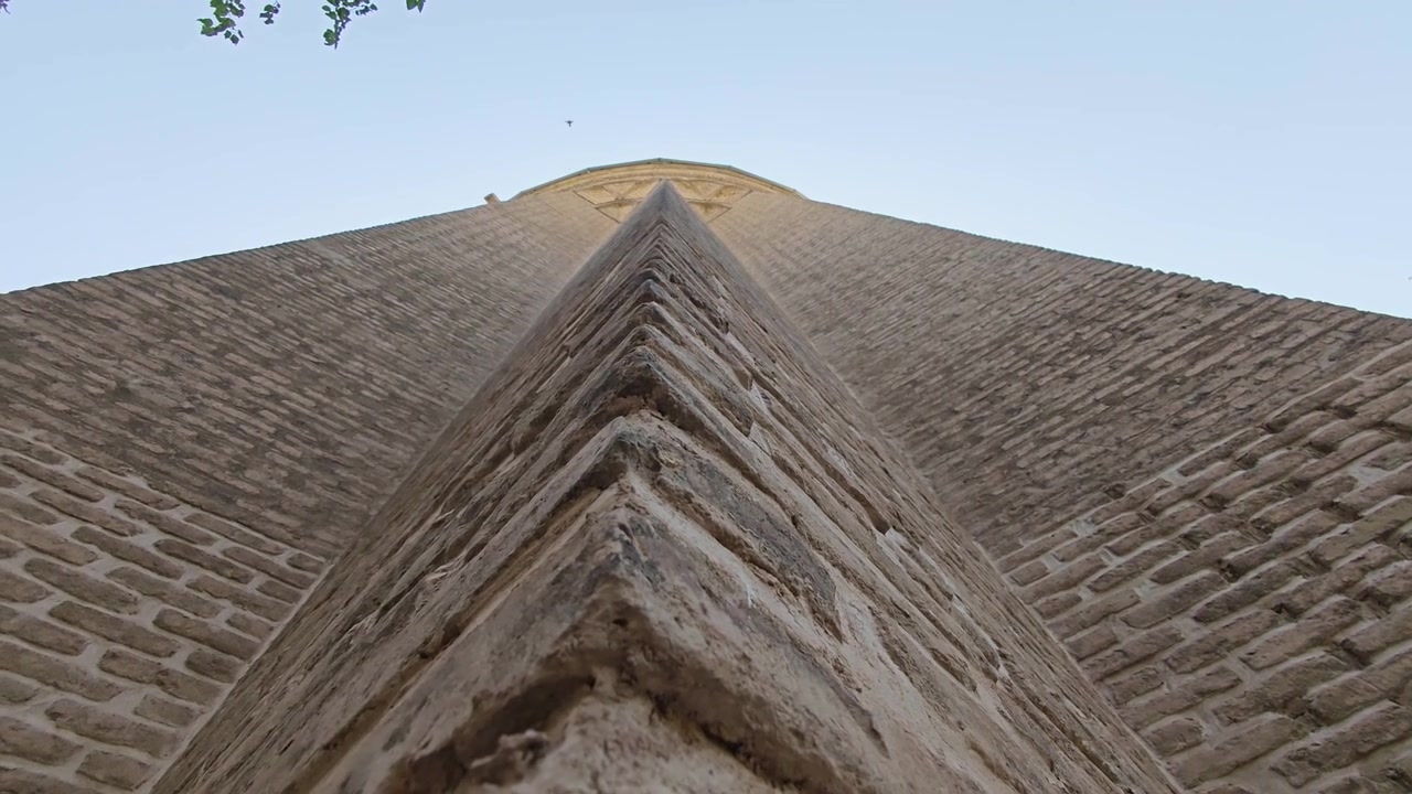 Pohled zdola na starobylý cihlový minaret