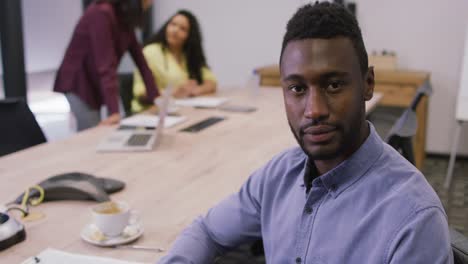 portrait of smiling african american businessman looking at camera in modern office