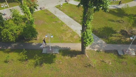 just married couple walks along green park aerial view