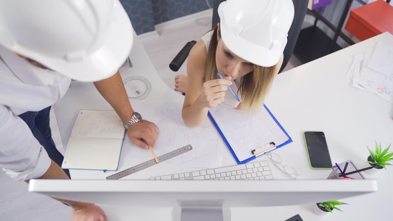 ingeniera y ingeniero trabajando en un proyecto de dibujo.