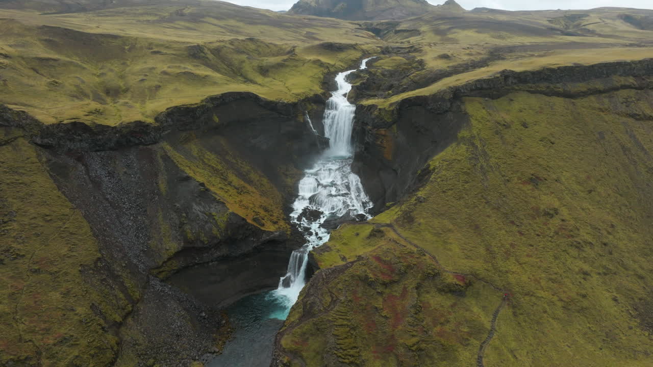 amplia salida aérea lejos de la majestuosa cascada ofaerufoss, tierras altas de islandia