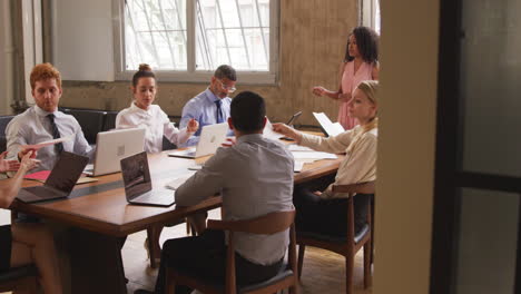 Black-female-boss-explaining-document-to-team-at-a-meeting