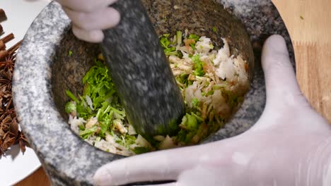 trituración de ajo, raíz de cilantro en mortero de piedra, primer plano-1
