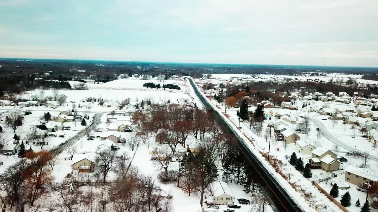 Wide aerial shot of flat snowy midwestern farmland. 4K
