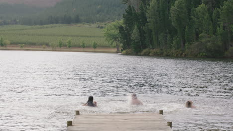 best friends jumping in lake having fun summer vacation enjoying freedom splashing in water on sunny afternoon