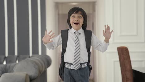 happy indian school boy saying hi to the camera