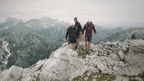 Un-Grupo-De-Excursionistas-En-Equipo-De-Escalada-Subiendo-La-Montaña-Hacia-La-Cámara-En-Condiciones-Nubladas