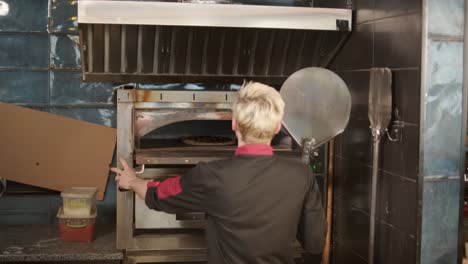 chef preparando coberturas de pizza en la cocina de un restaurante