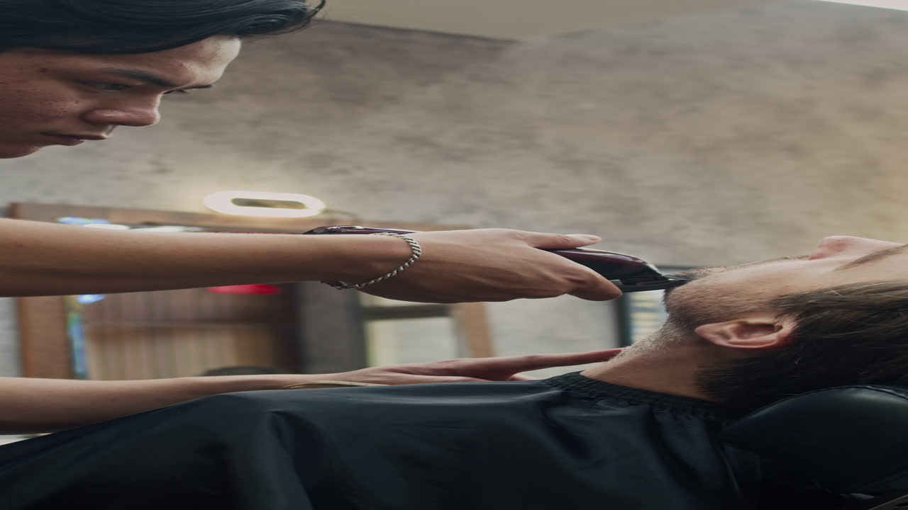 Barber Trimming Stubble of Male Client in Salon