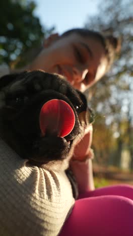 woman and her pug in a park