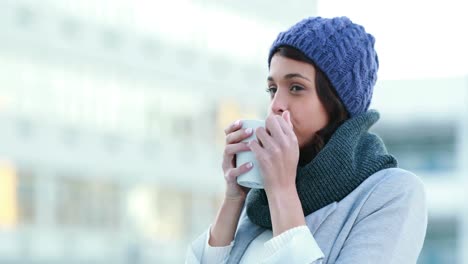 smiling woman drinking hot beverage