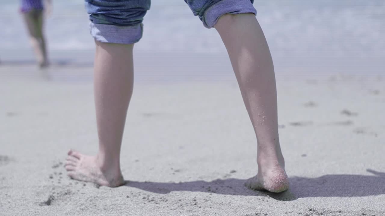 여름에 모래사장을 걷는 아름다운 젊은 여성의 다리를 슬로우 모션 클립