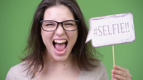 young beautiful woman shouting while holding selfie paper sign