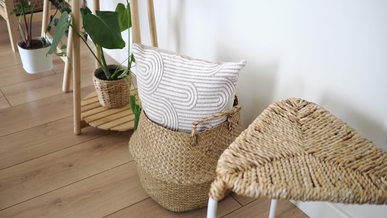 Angolo di casa elegante con cesto intrecciato e piante in vaso.