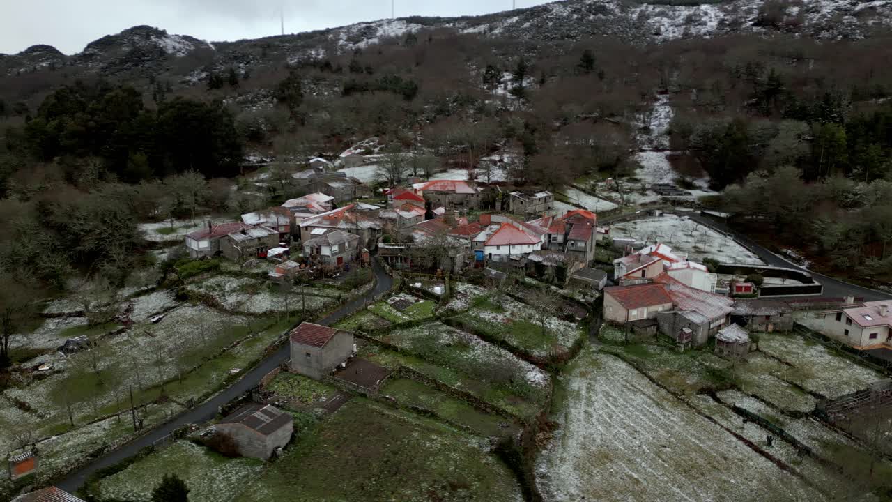 заснеженная деревня с растительностью зимой под пасмурным небом в пикорнио, городе в галисии