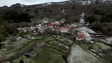 pueblo nevado con vegetación en invierno bajo un cielo nublado en picornio, un pueblo en galicia