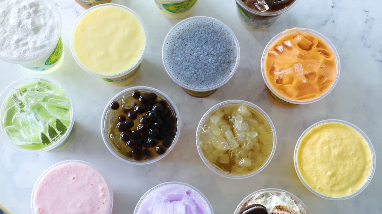 남성 손이 보바와 함께 아이스티를 평평한 테이블 세팅 위에 내려놓는다