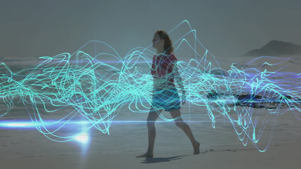 Donna che cammina sulla spiaggia con onde ciano che si intensificano intorno al busto, poi allarga le braccia abbracciando la tecnologia
