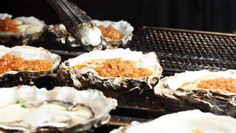 oysters being grilled with toppings in hong kong