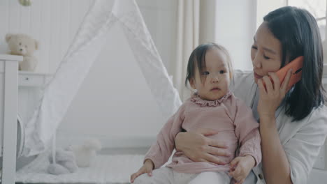 mother talking on the phone with her baby daughter