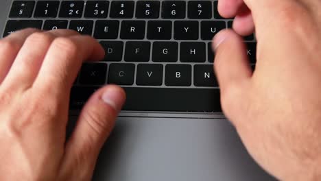 Close-up-shot-of-man-typing,-writing-an-email,-working-from-home-in-home-office-on-MacBook-Pro