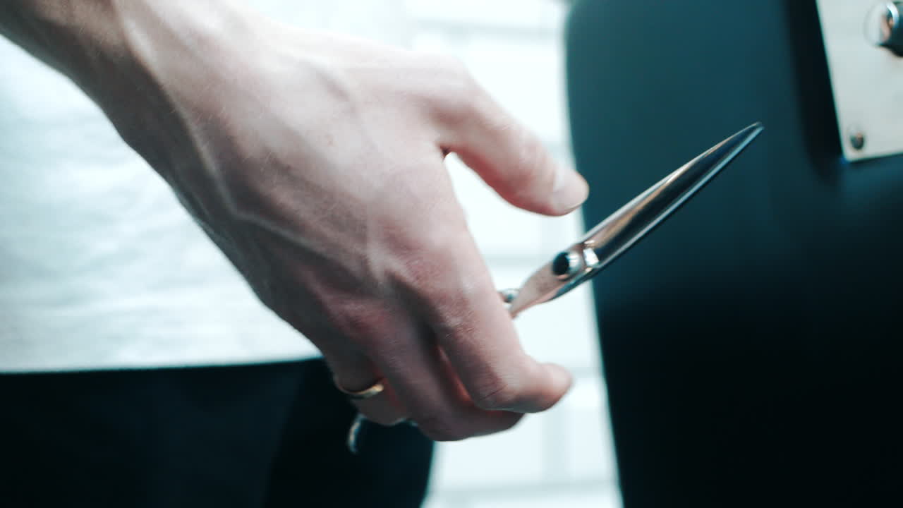 머리카락을 자르기 위해 손에 가위를 들고 있는 미용사