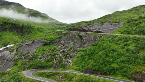 Revealing-Vikafjellet-mountain-pass-from-the-winding-roads-at-Halsabakkane---Ascending-into-beautiful-clouds-with-road-leading-into-vast-mountain-landscape