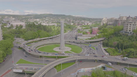 Toma-Aérea-Sobre-Un-Cruce-De-Carreteras-Muy-Transitado-Y-Automóviles-Que-Viajan-A-Través