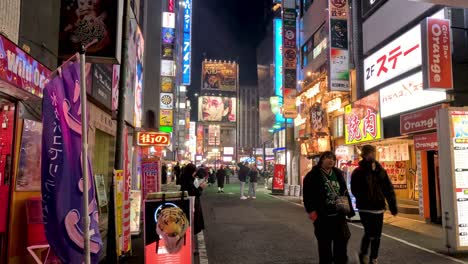 pedestrians walking on a vibrant, illuminated urban street